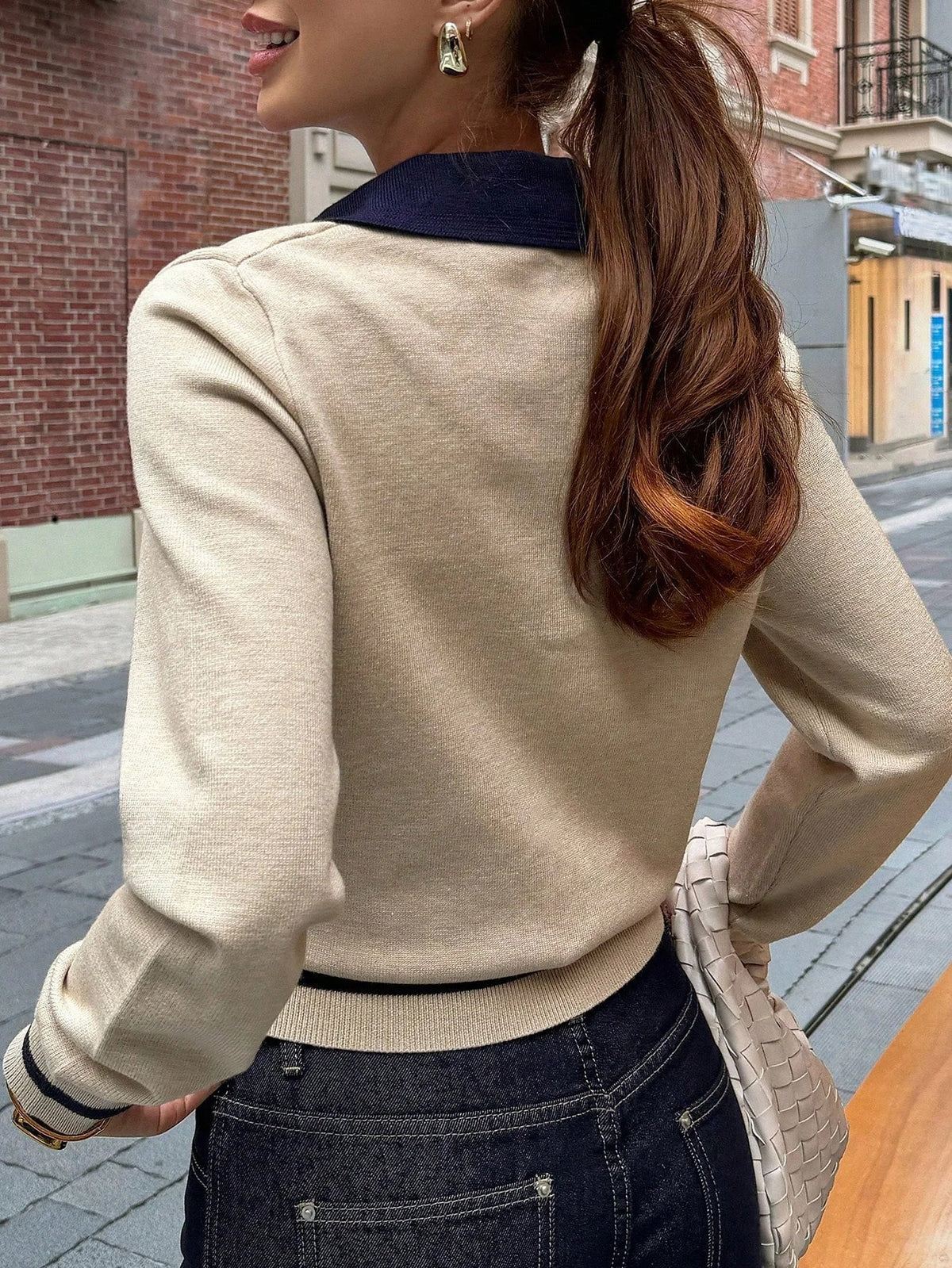Close-up of ribbed knit texture and polo neckline on women's color block top