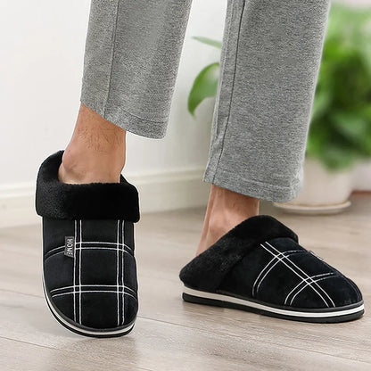 Pair of Huxley plush slippers in brown displayed on wooden floor