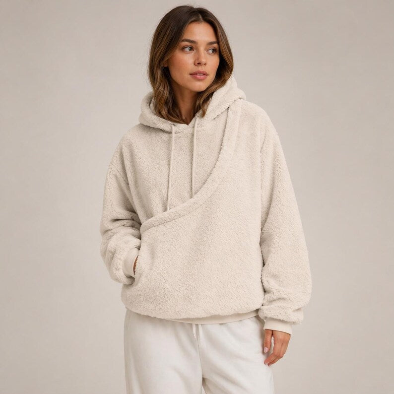 Woman wearing pink fleece hoodie holding dog in kangaroo pocket