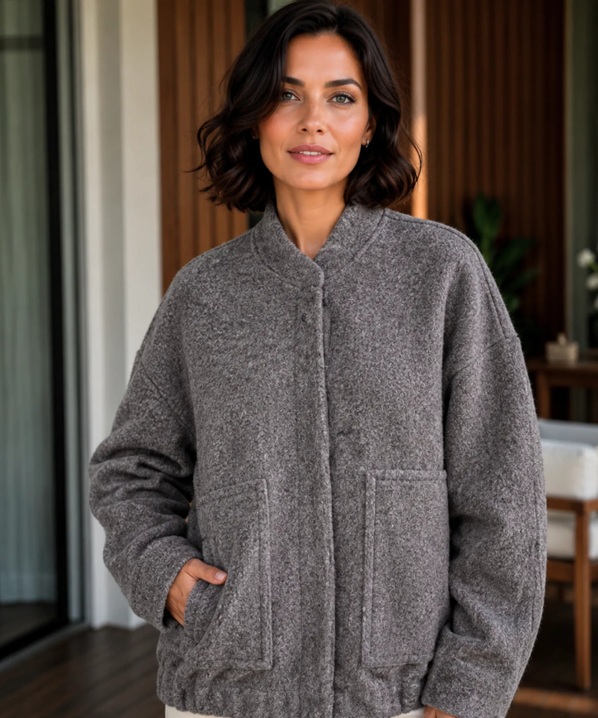 Close-up of bouclé wool texture on women's bomber jacket in olive green