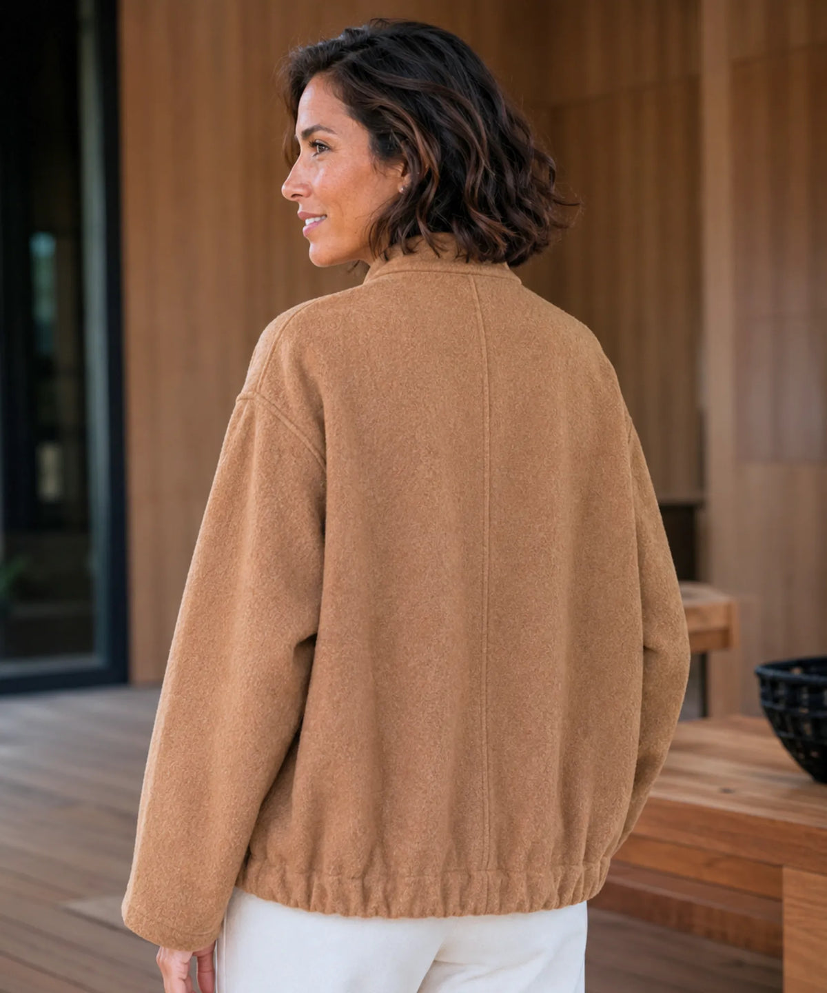 Woman wearing oversized bouclé bomber jacket in nude toned colour