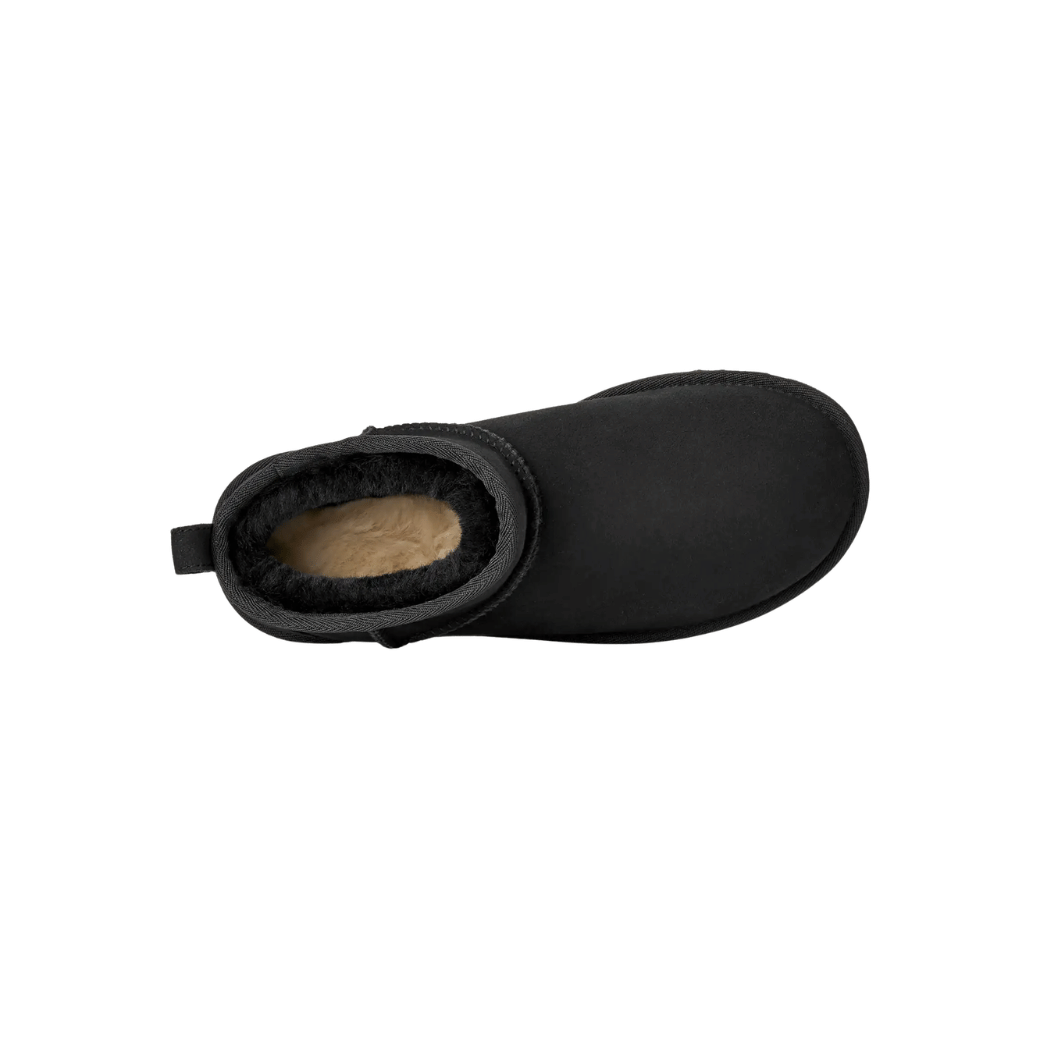 Black mini sheepskin boot side angle on model
