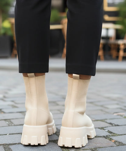 Full-length view of women's black knit sock boot with lug sole