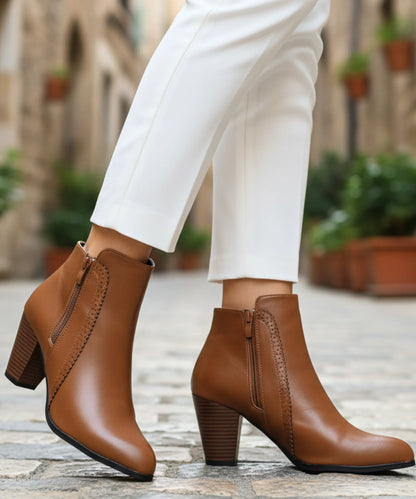 Women's black leather ankle boots with perforated seam detail and side zip